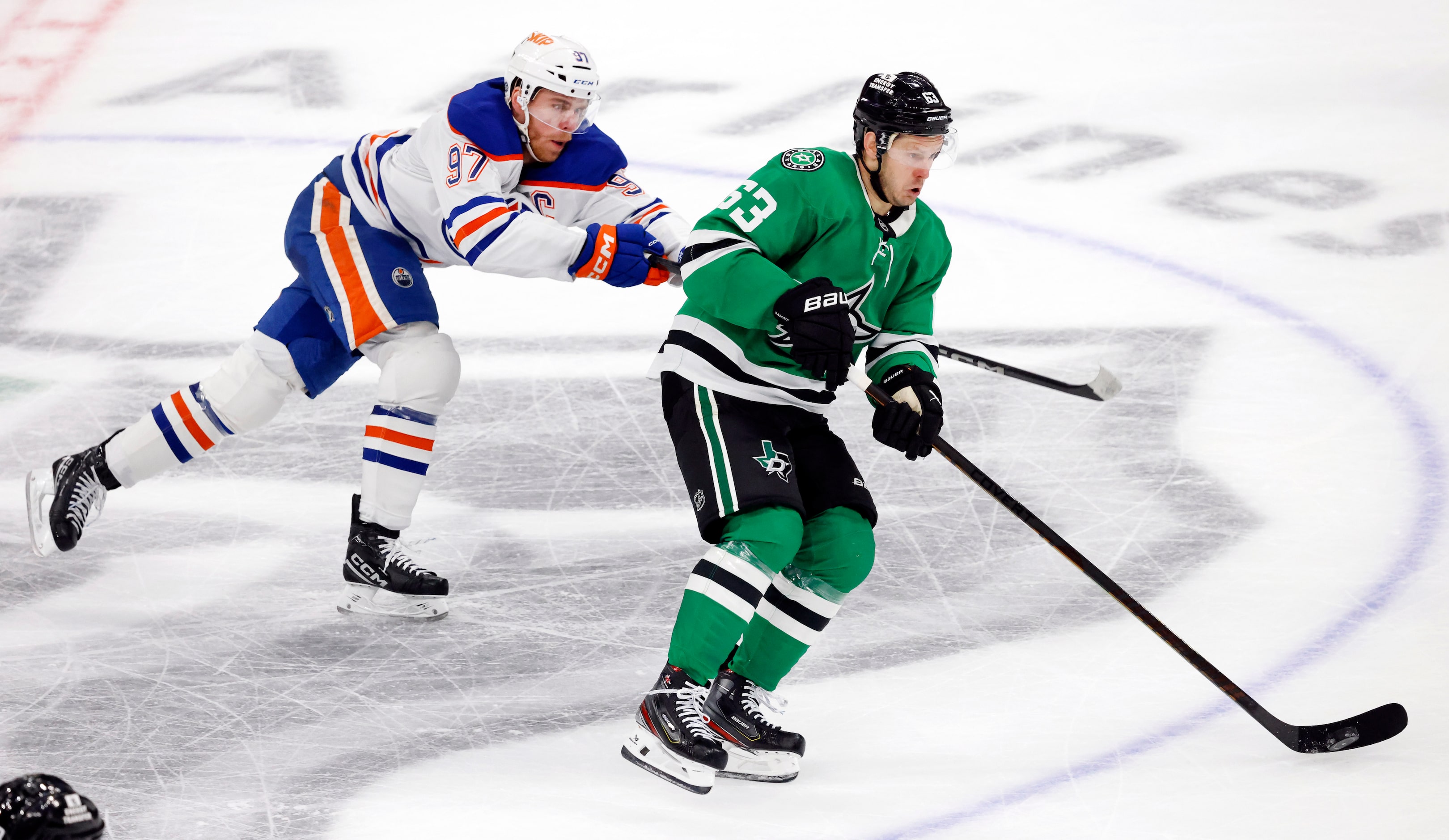 Edmonton Oilers center Connor McDavid (97) tries to hack Dallas Stars right wing Evgenii...