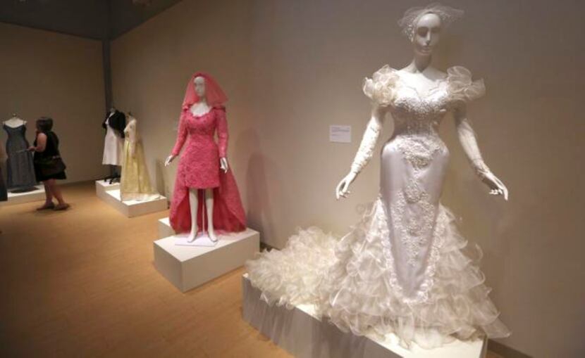 
A wedding dress made in 1985 (foreground) and a pink gown from 1994 are on display in...