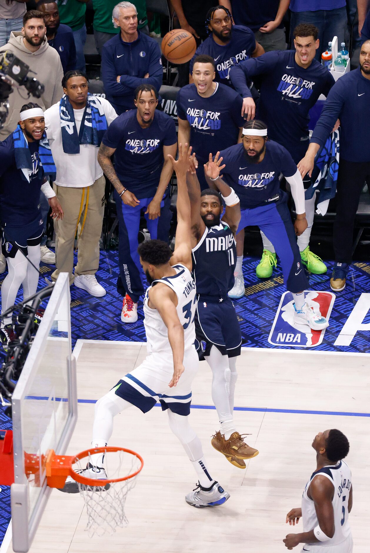 The Dallas Mavericks bench players watch as guard Kyrie Irving (11) sinks a shot over...