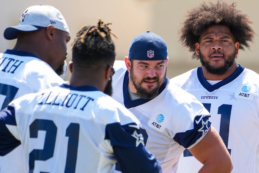 Dallas Cowboys guard Zack Martin (70) leans into the huddle with tackle Tyron Smith (77),...