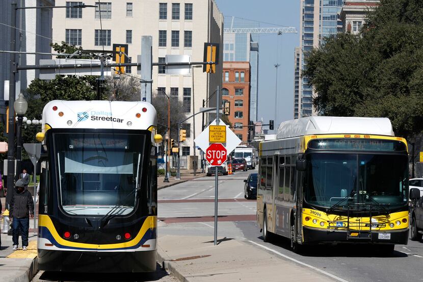 The Dallas Streetcar waits for passengers at Houston and Young Streets as a DART bus makes...
