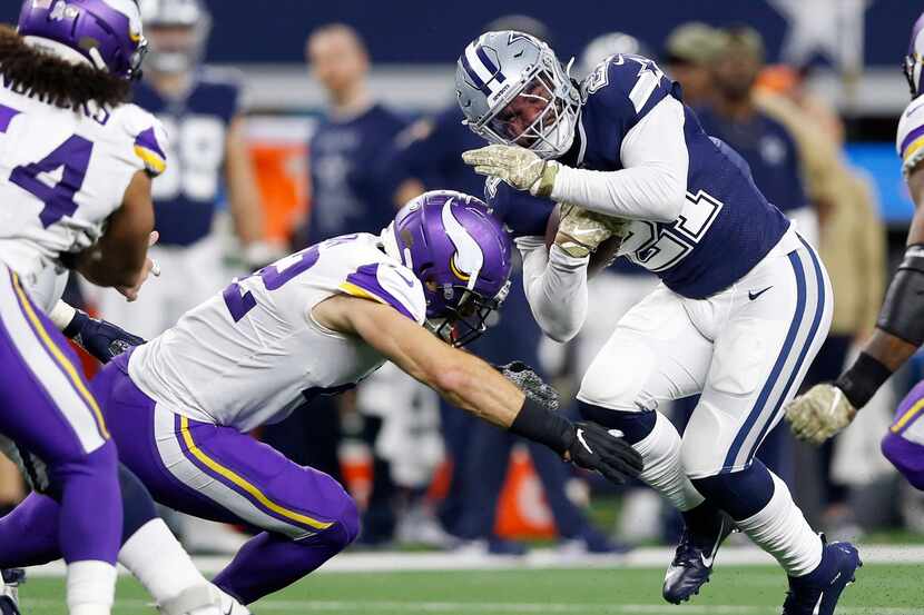 Dallas Cowboys running back Ezekiel Elliott (21) is tackled by Minnesota Vikings outside...