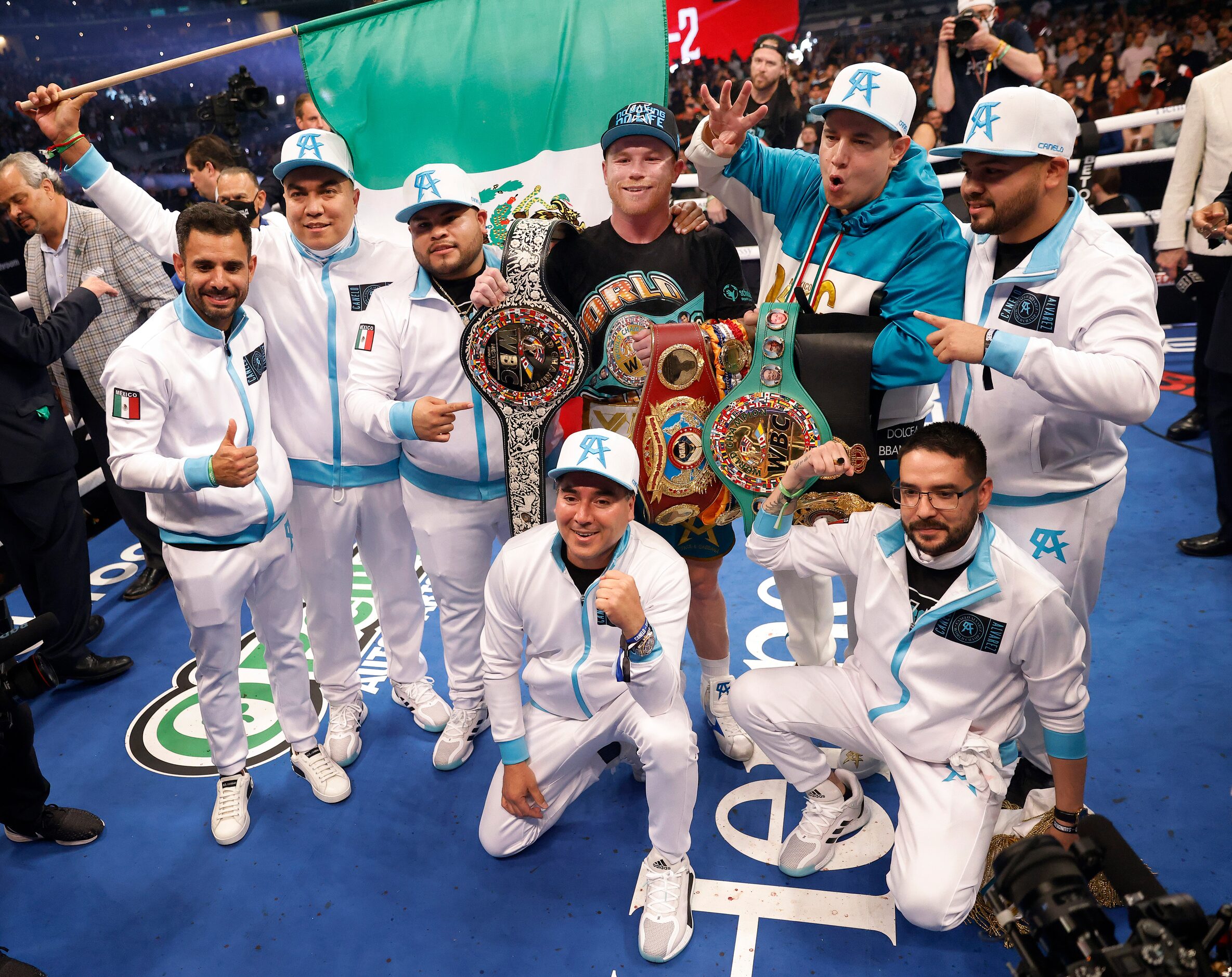 Boxer Canelo Alvarez (center) poses for a photo with his team and belts after defeating...