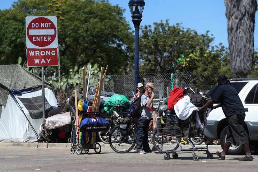 Homeless people crowd a parkway with tents and makeshift housing Wednesday, July 6, 2016, in...