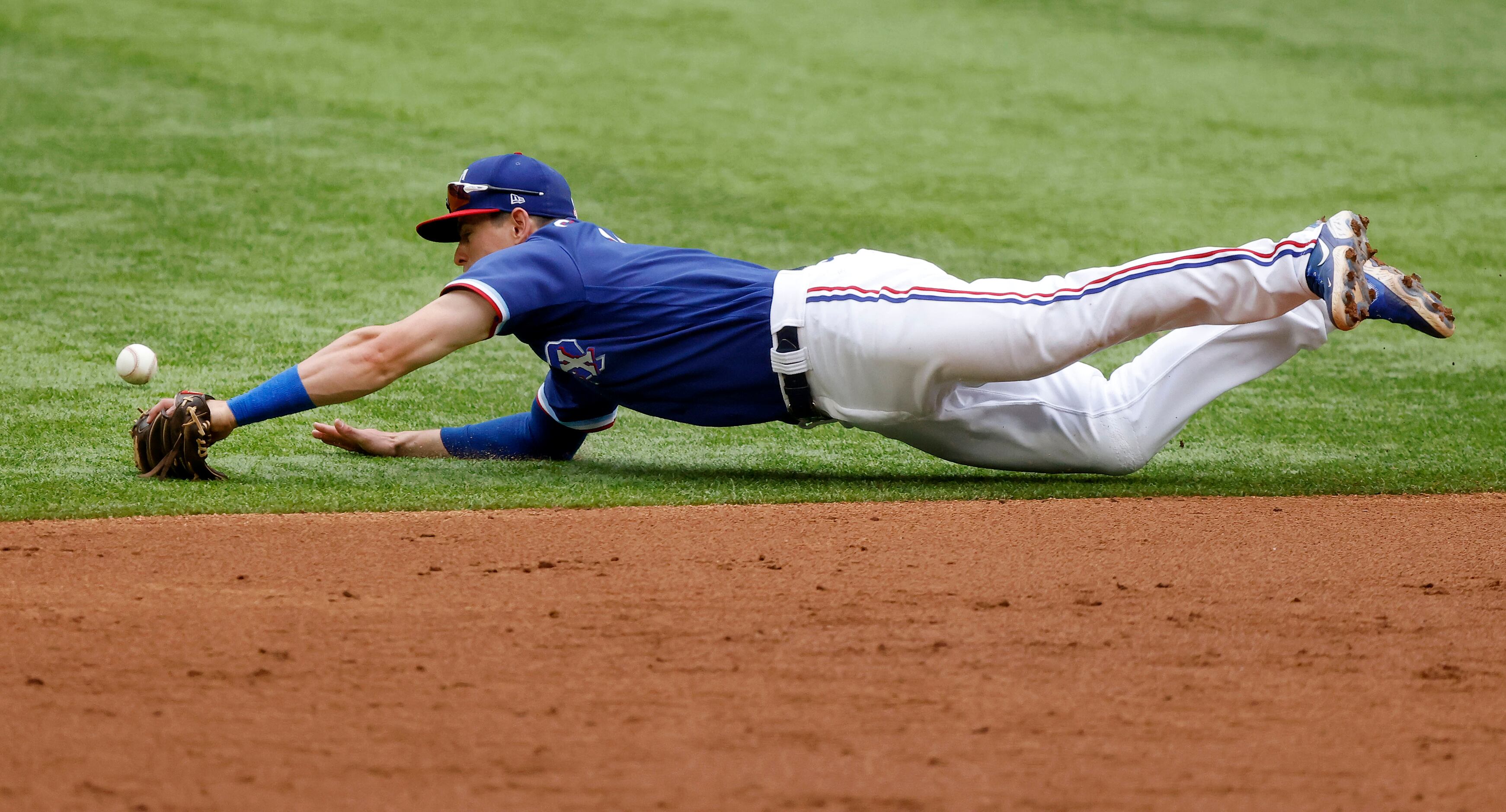 Texas Rangers second baseman Nick Solak (15) dives and narrowly misses a grounder by...
