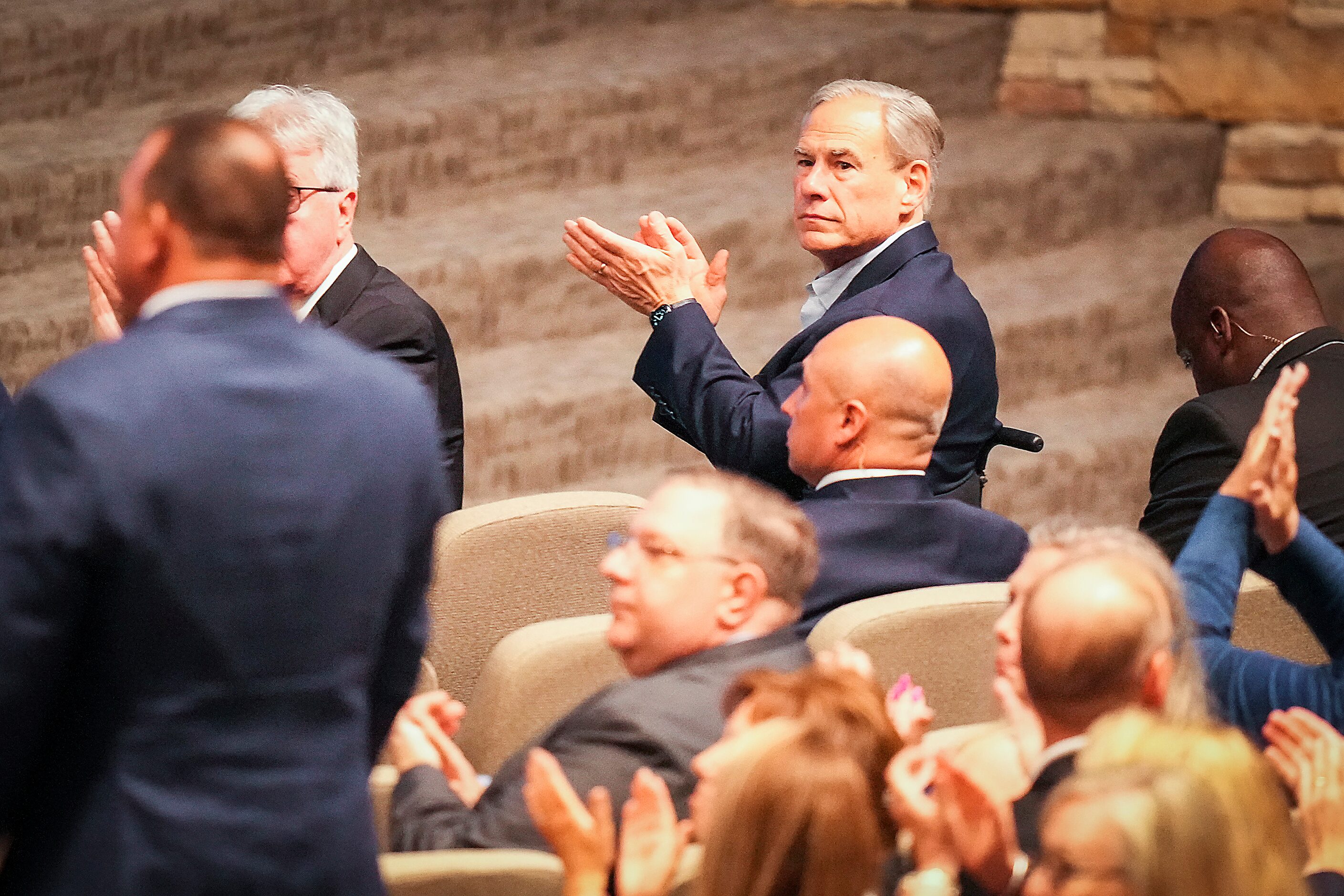 Texas Gov. Greg Abbott applauds as first responders are recognized during a vigil at...