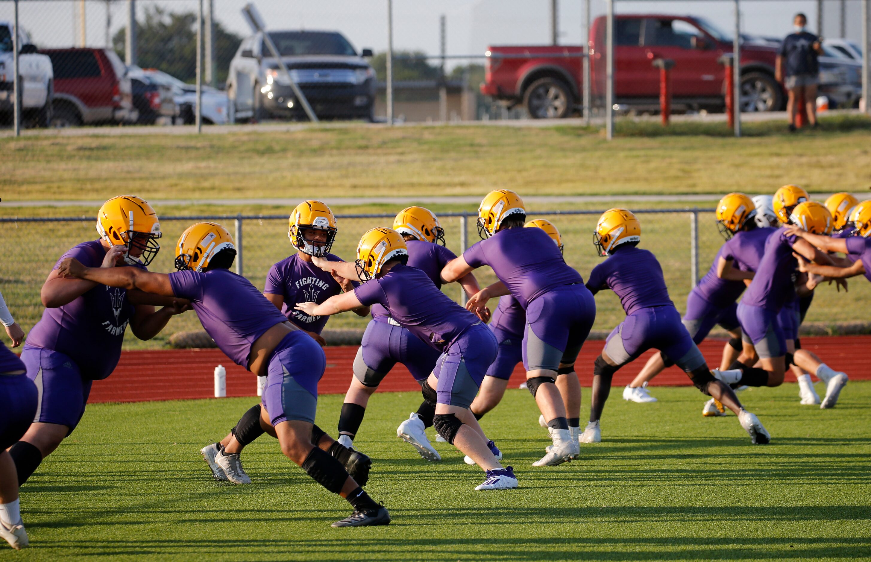 Linesmen run through a drill during the first day of high school football practice for 4A's...