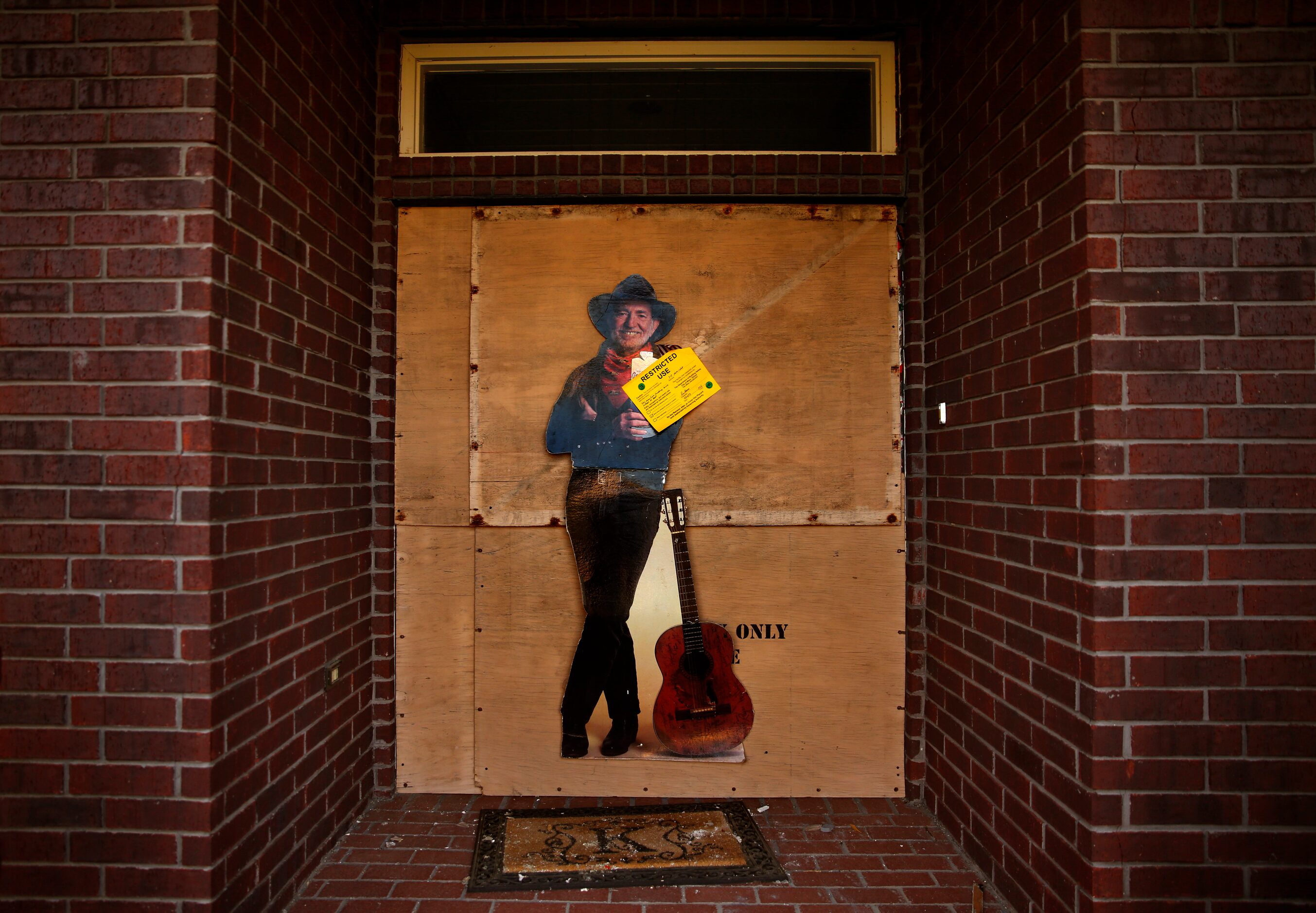 2013 - A cutout figure of Willie Nelson was tacked to the boarded-up front door of a damaged...