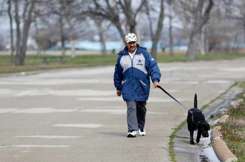 
Joaquin Amamaya walks his dog, Hero, on the south end of Elgin B. Robertson Park at Lake...
