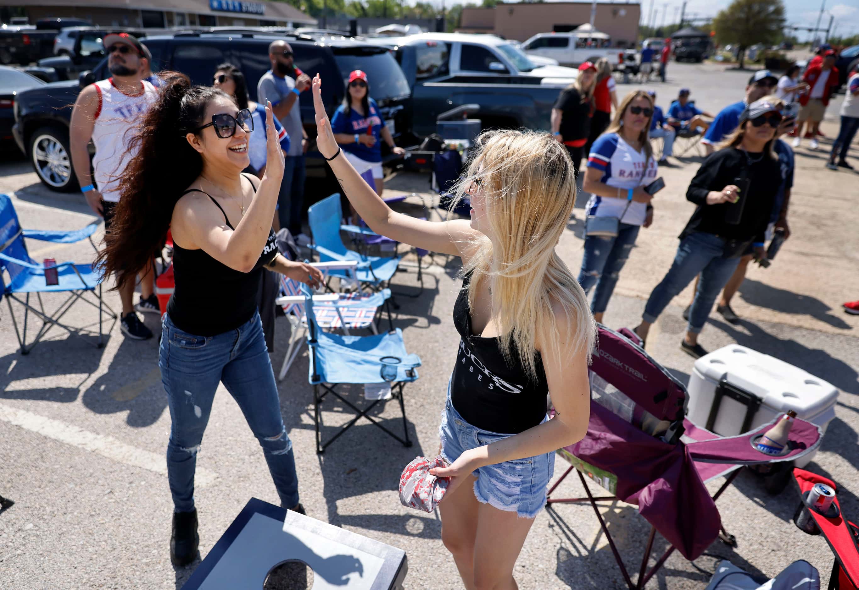 Texas Rangers fans Lola Martinez (left) and Kaylee Benson high five after they scored on a...