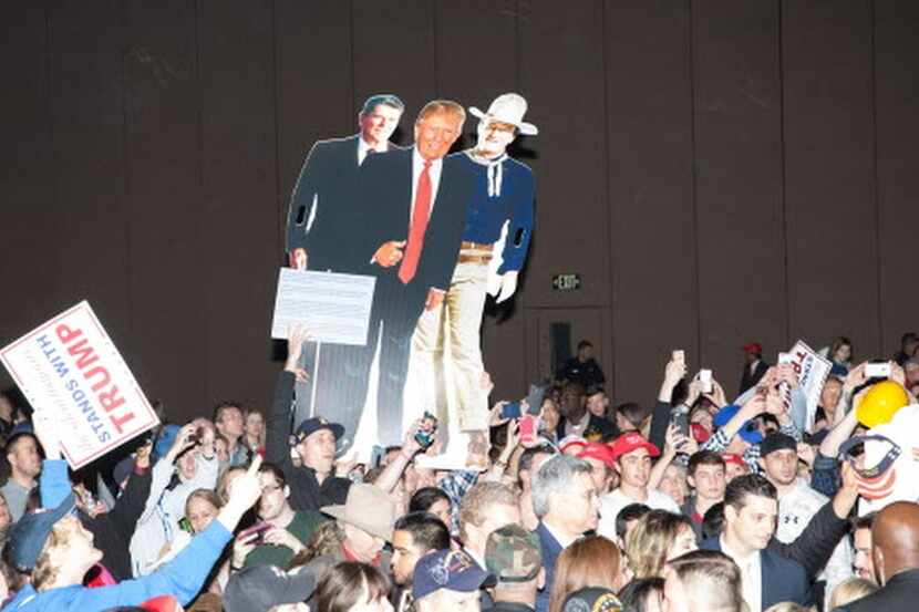 
Attendees at a Trump campaign rally in Fort Worth hold up life-sized cardboard printouts of...