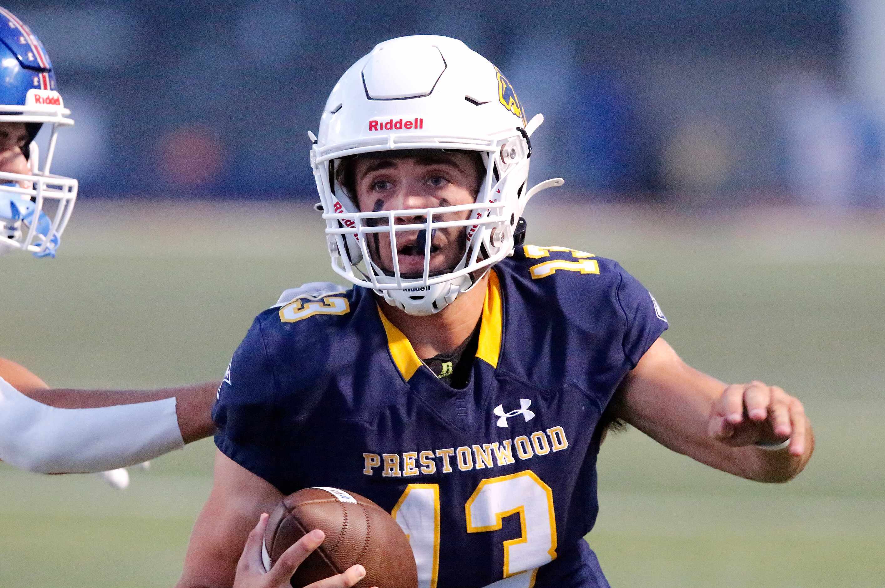Prestonwood Christian Academy quarterback Maguire Martin (13) looks for room to run during...