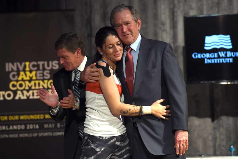 Former US President George W. Bush hugs US Coast Guard Yeoman 3rd Class Kristen Esget, as...