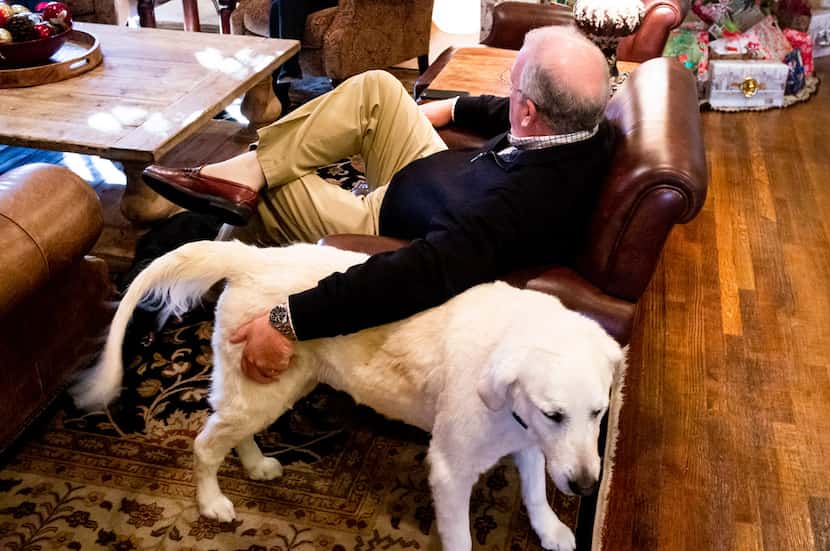 Glen Carter pets his dog, Ace,  as he talks to his wife, Janet, in their University Park home.