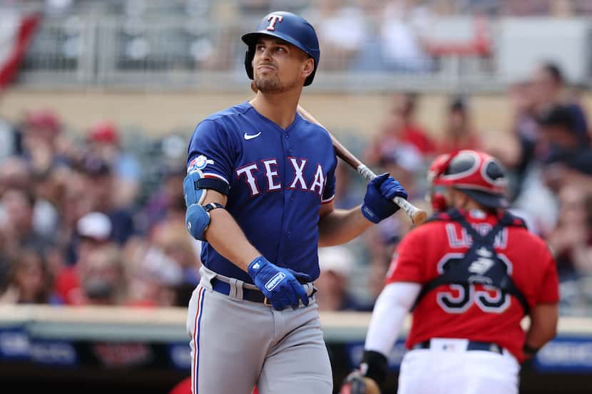 Texas Rangers' Nathaniel Lowe reacts after striking out during the first inning of a...
