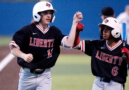 Liberty pinch runner Caden Wartluft (11) is congragulated by left fielder Isaiah Sandoval...