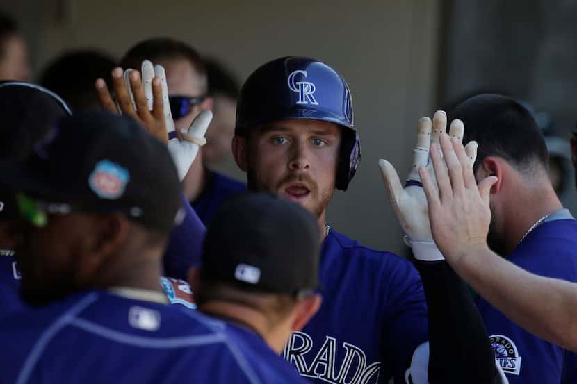 Trevor Story, an Irving graduate, is greeted in the Colorado dugout after hitting a solo...