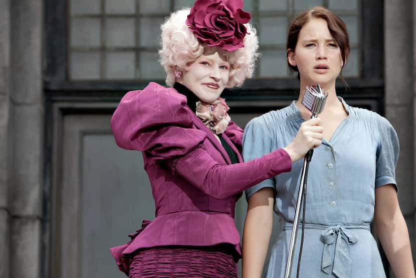 Elizabeth Banks portrays Effie Trinket, left, and Jennifer Lawrence portrays Katniss...
