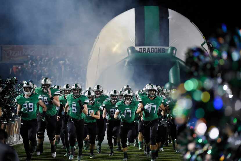 The Souhlake Carroll team runs onto the field during the Bi-district high school football...