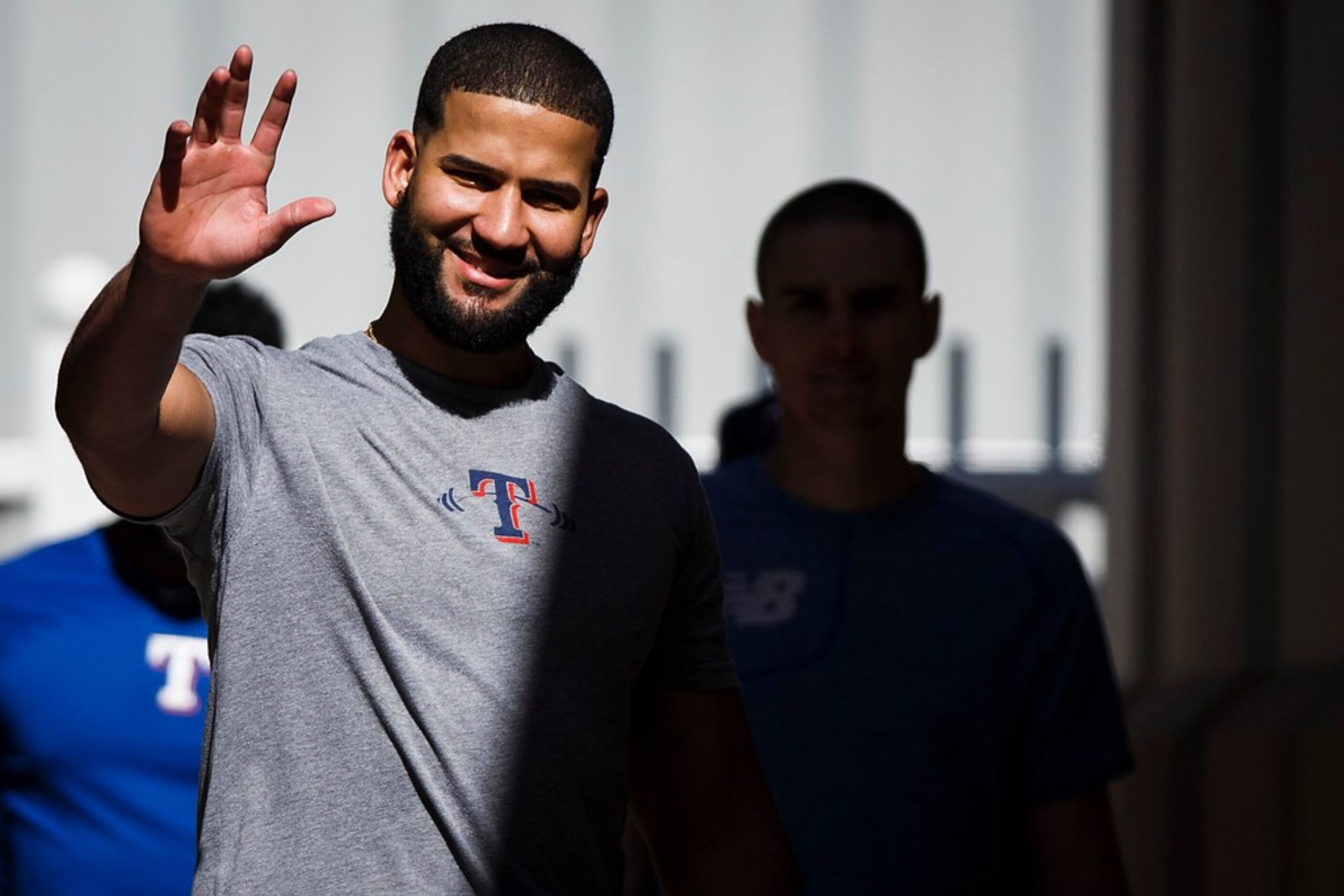 Texas Rangers outfielder Nomar Mazara waves to photographers during a spring training...