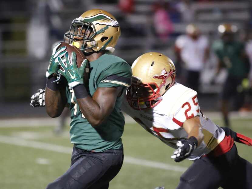KD Nixon of DeSoto High School pulls in a pass in front of Jakari McDowell of South Grand...