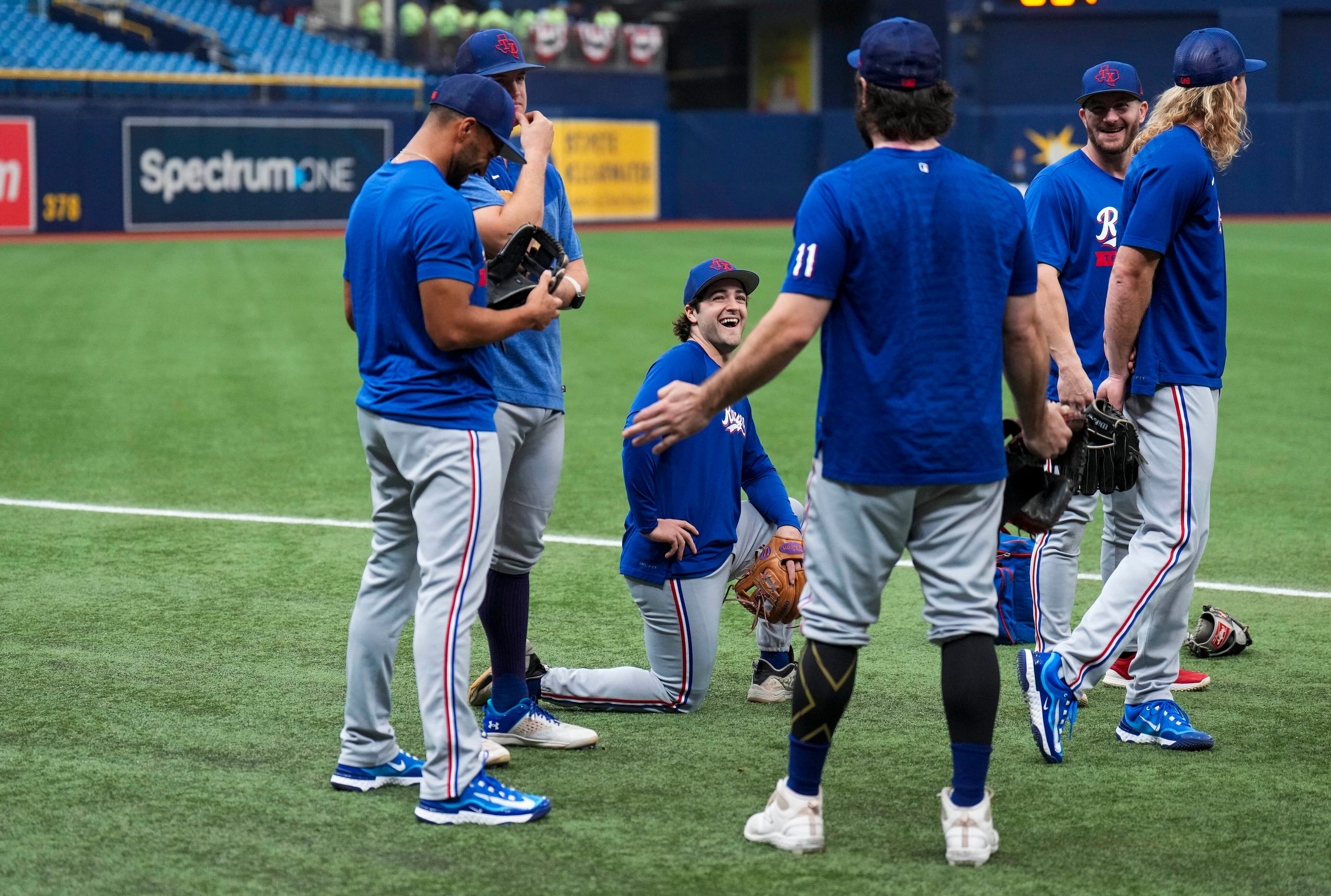 Texas Rangers shortstop Josh Smith (facing) laughs with teammates as they prepare to warm up...