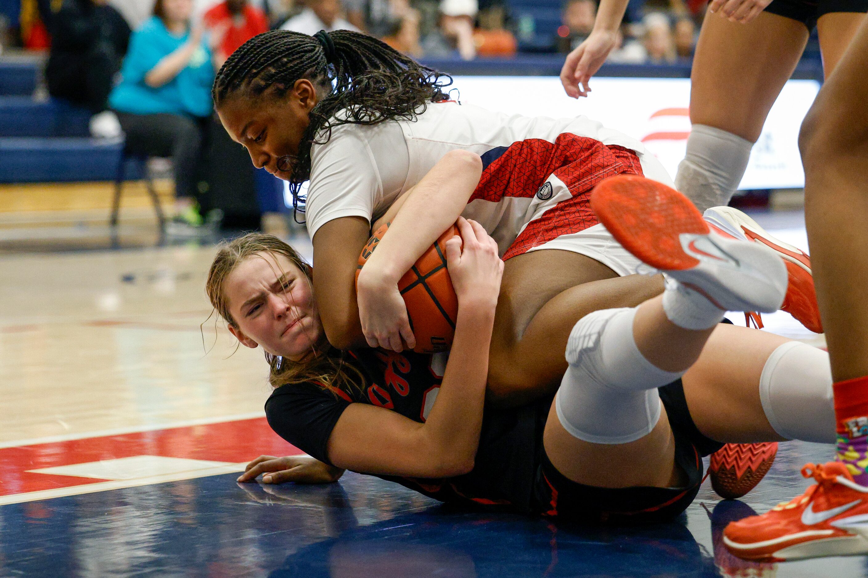 Argyle forward Landry Murphy (22) and Denton Ryan guard Atiya Everett (3) wrestle for a...