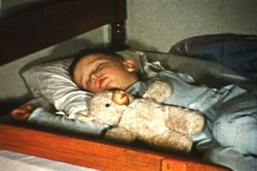 Baby Ron Siebler sleeps with his teddy bear on Christmas Eve, 1954.