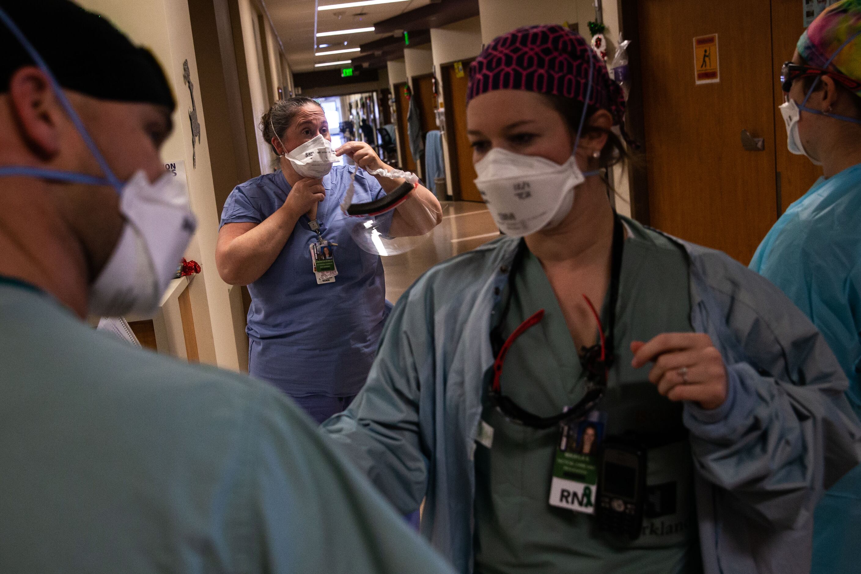 Rowley (center) suits up with personal protective equipment to help with a patient’s...