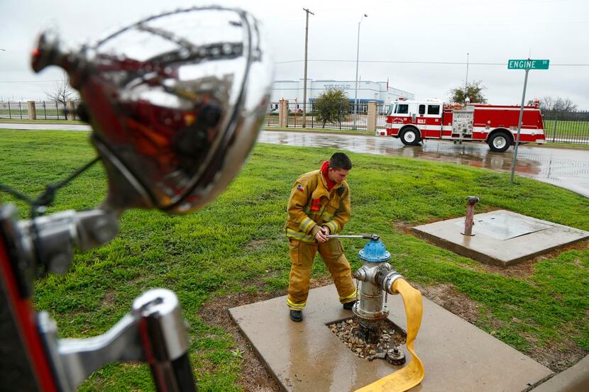 
Micah Wesberry opens up a fireplug while training with other Garland firefighters in a...