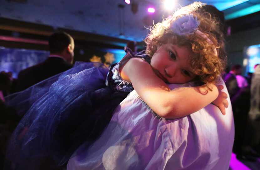  Lucy Komonchak, 4, rests on her father Andy Komonchak's shoulder during the 19th Annual...