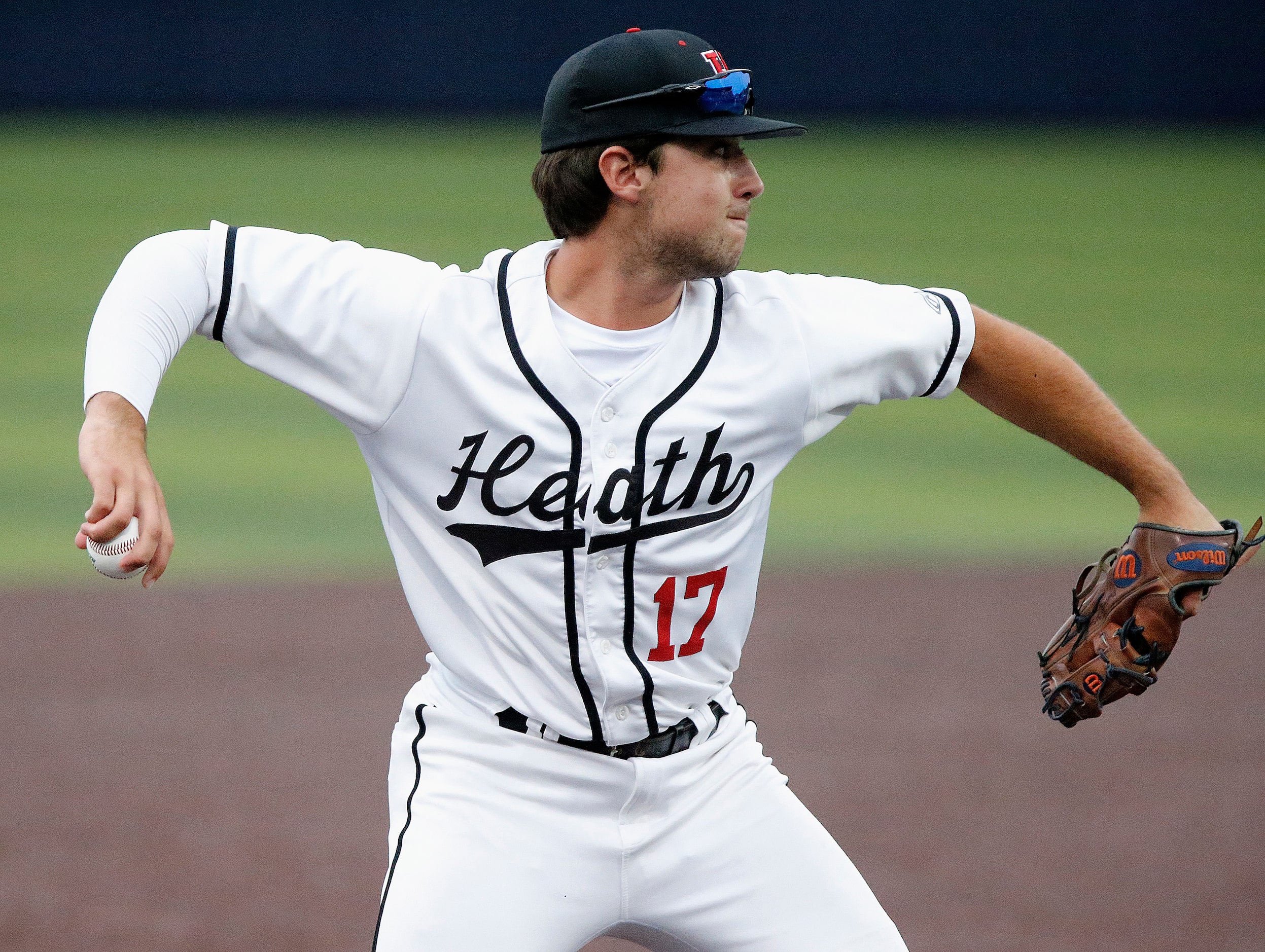 Heath third baseman Josh Hoover (17) makes the throw for an out in the first inning as...