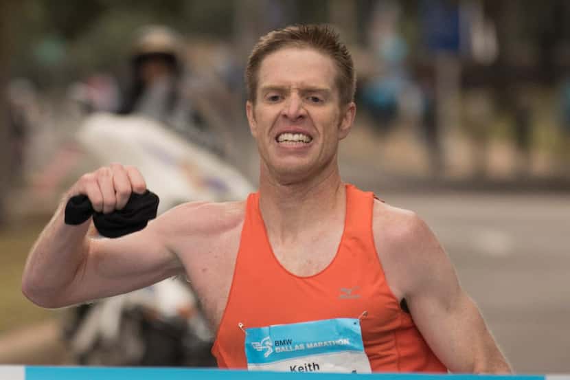 Keith Pierce, of Lewisville, crosses the finish line to win the BMW Dallas Marathon on...
