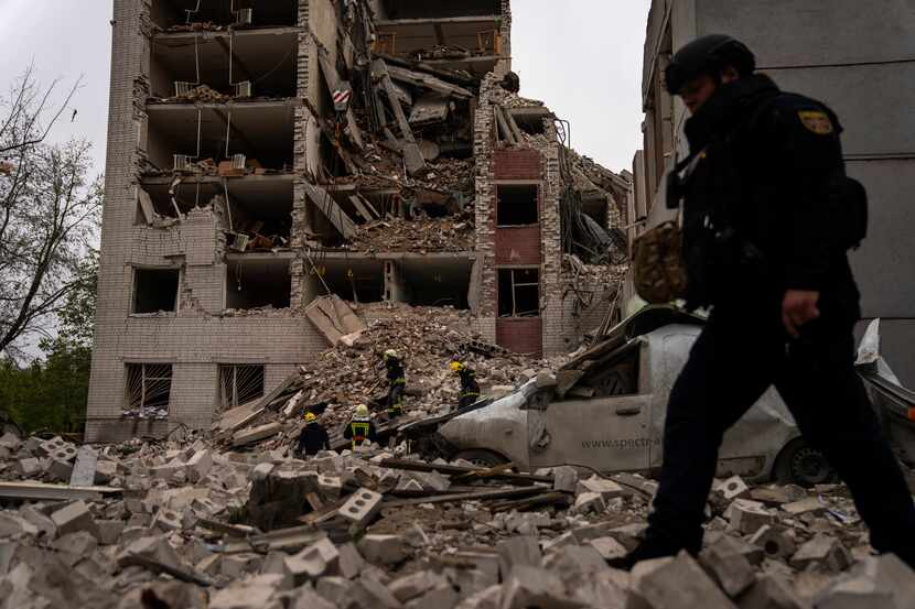 Firefighters work on a building that was partially destroyed after a Russian bombardment in...