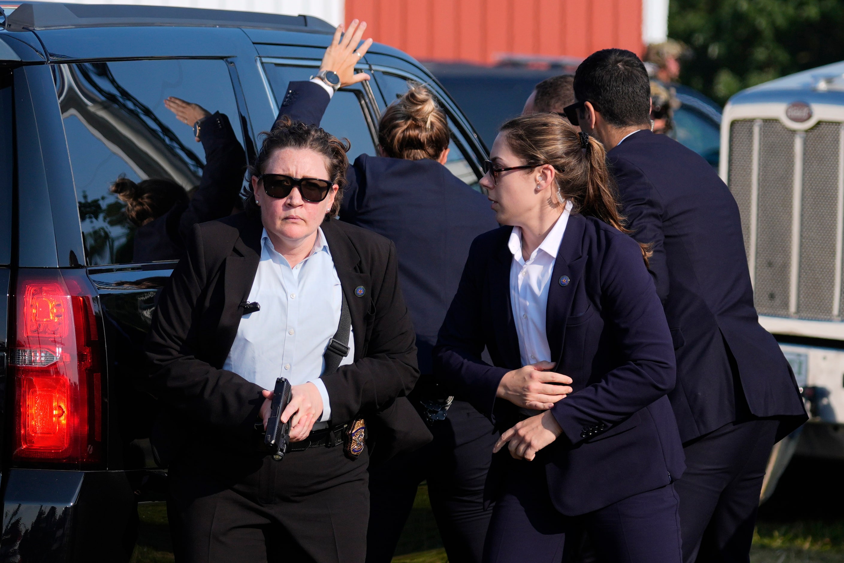 U.S. Secret Service agents surround the vehicle carrying Republican presidential candidate...