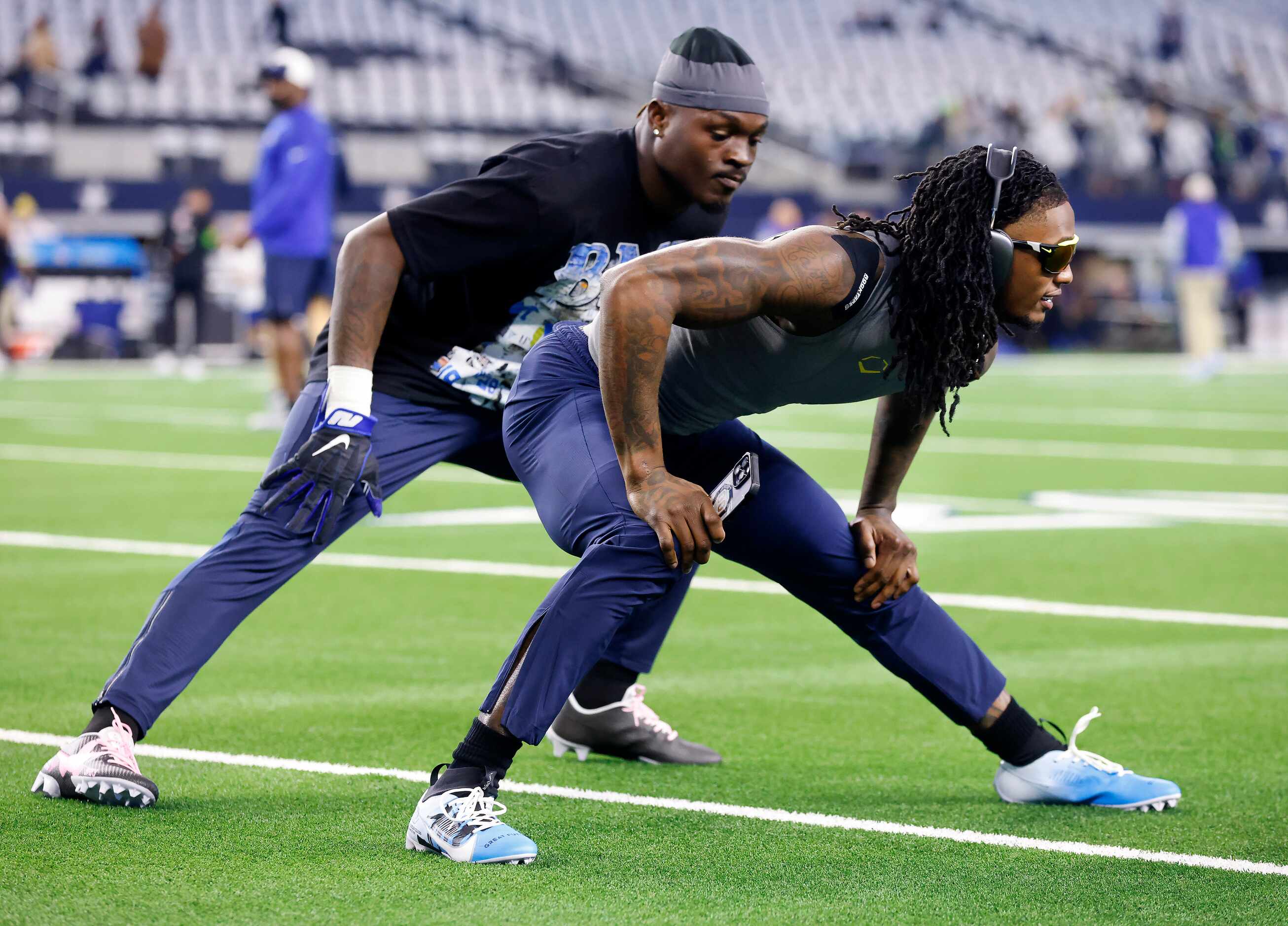 Dallas Cowboys wide receiver CeeDee Lamb (front and linebacker Damone Clark stretch in their...