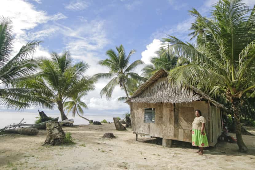 Local woman stands by her palm thatch house in Walung, an isolated village in Kosrae,...