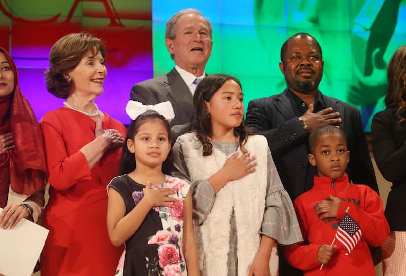 Former President George W. Bush and former first lady Laura Bush recite the pledge of...