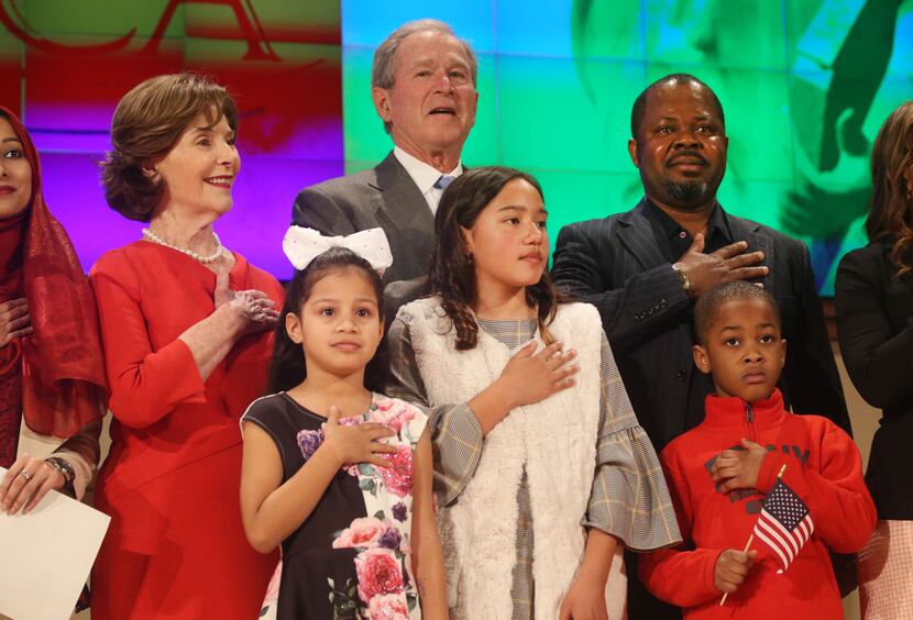 Former President George W. Bush and former first lady Laura Bush recite the pledge of...