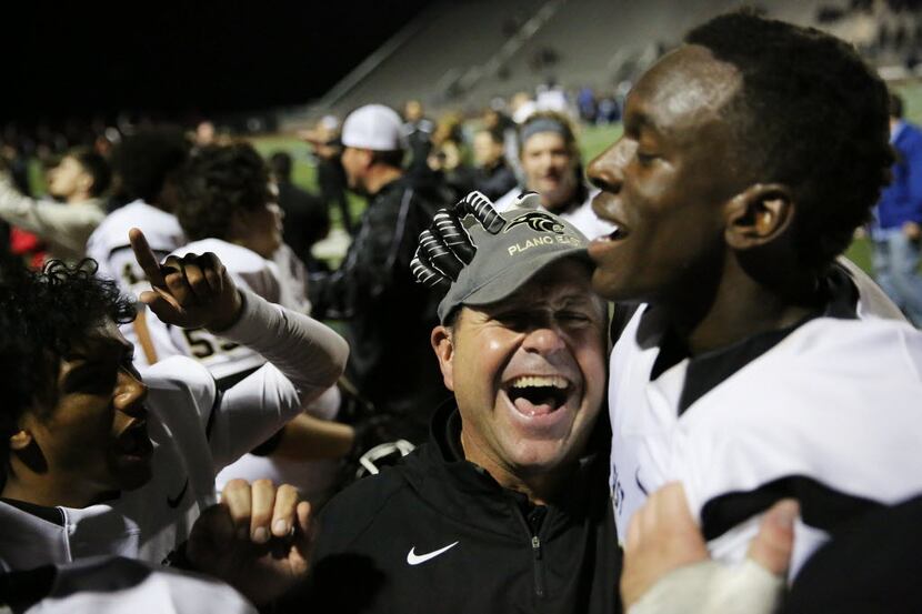 Plano East head coach Joey McCullough celebrates with wide receiver Audie Omotosho (right)...