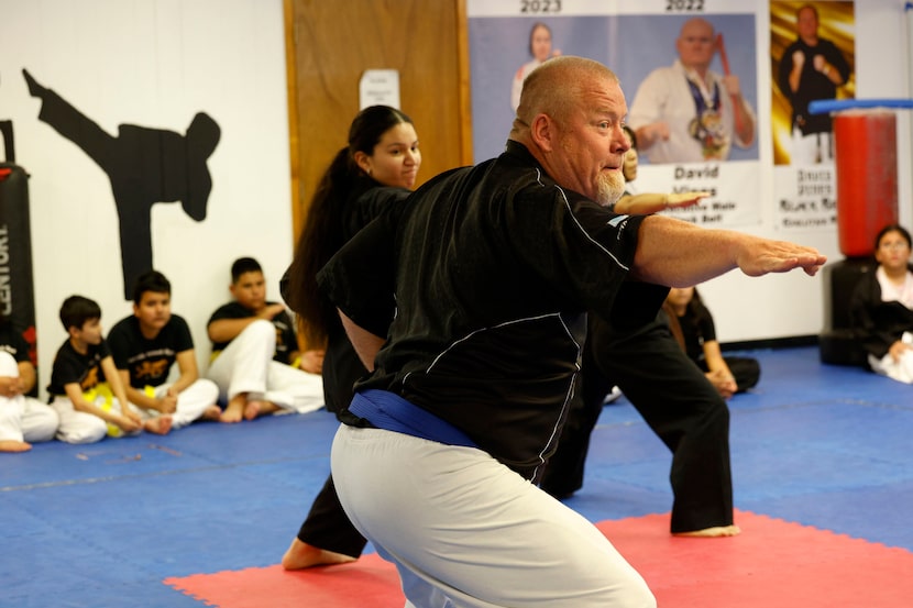 Conrad football coach Josh Ragsdale demonstrates forms of taekwondo for students in a...