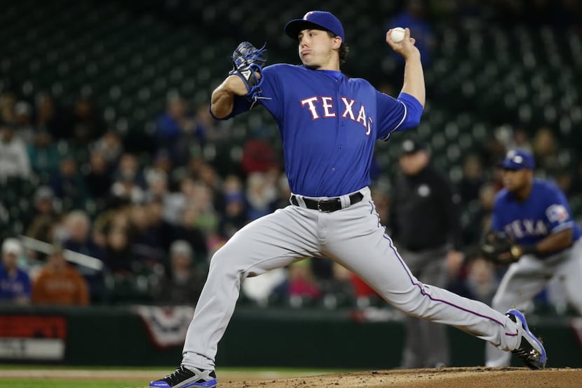 Texas Rangers starting pitcher Derek Holland throws to a Seattle Mariners batter during the...