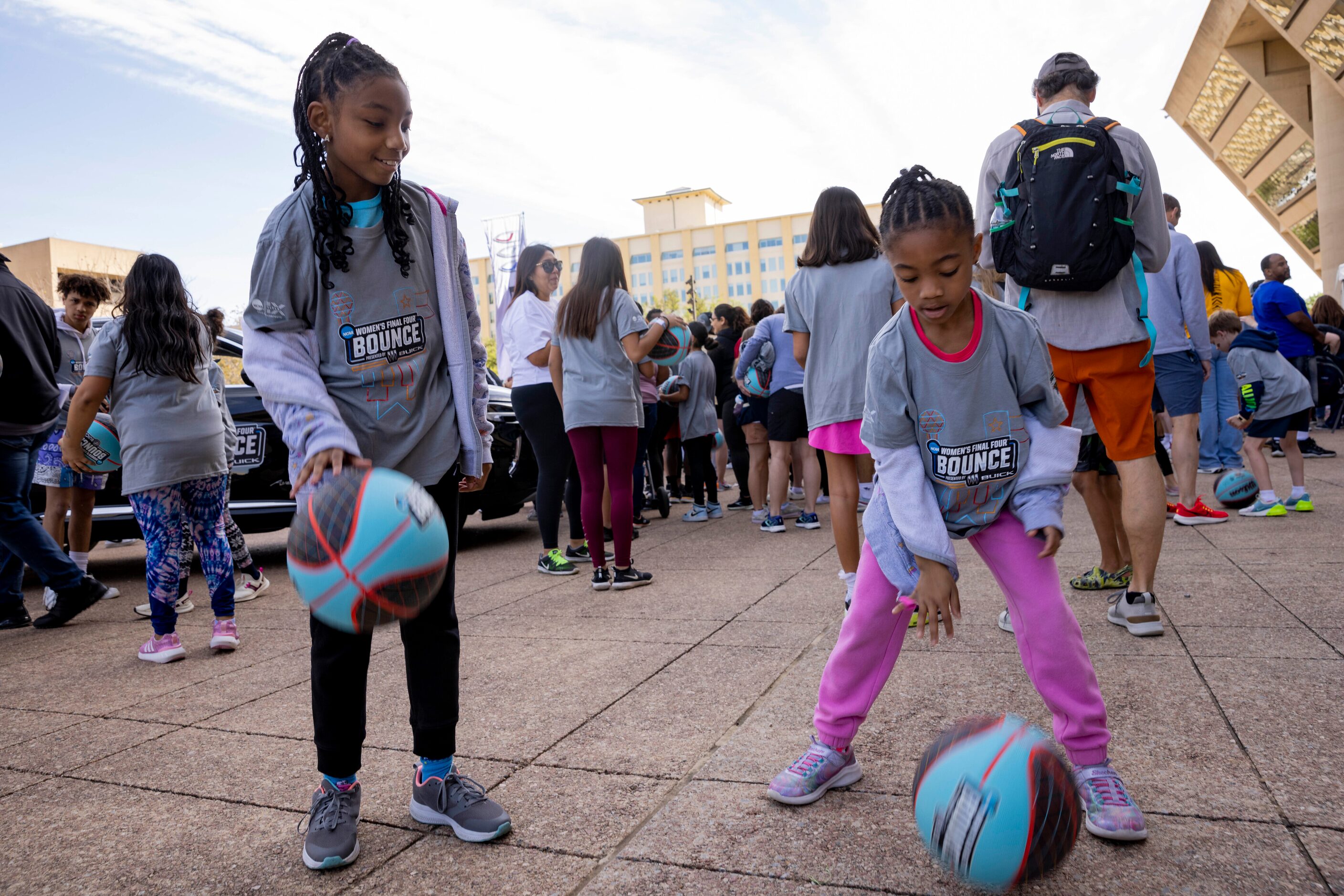 Aniya Calhoun, 11, of Grand Prairie watches as sister Madison, 7, practices dribbling before...