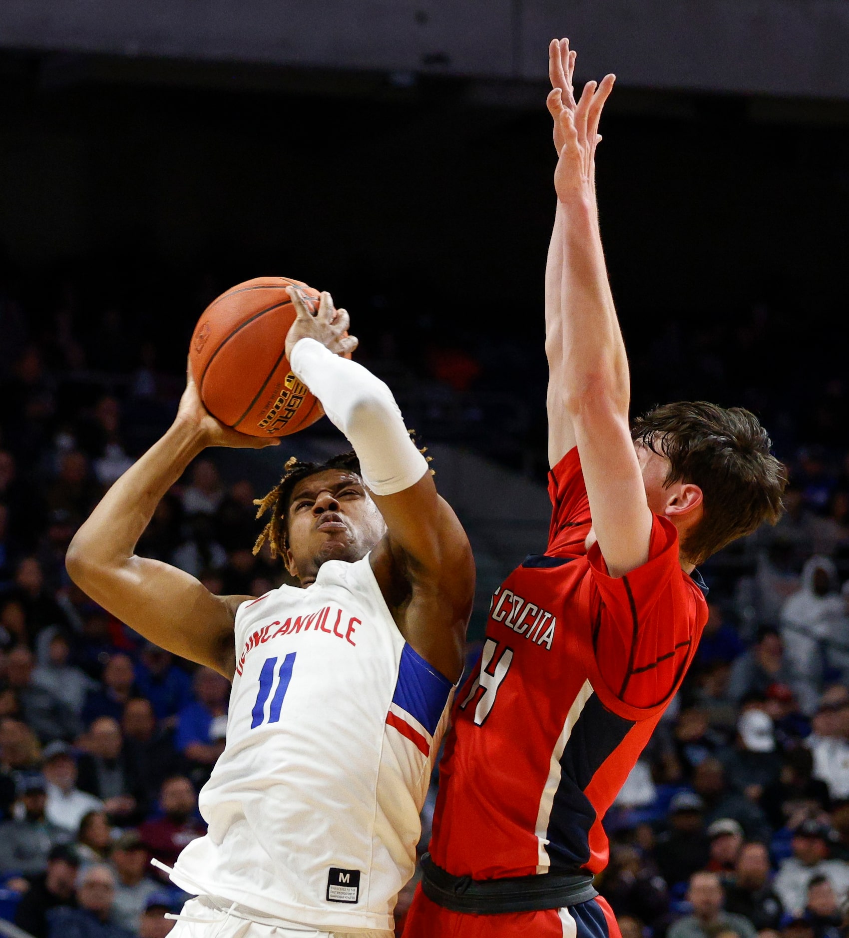 Duncanville guard Aric Demings (11) attempts a layup in front of Humble Atascocita guard...