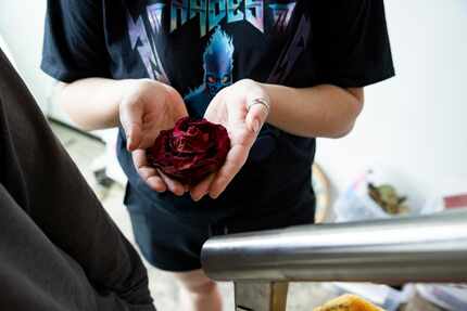 Floral preservation artist Francesca Mackey holds a flower damaged by the flooding.