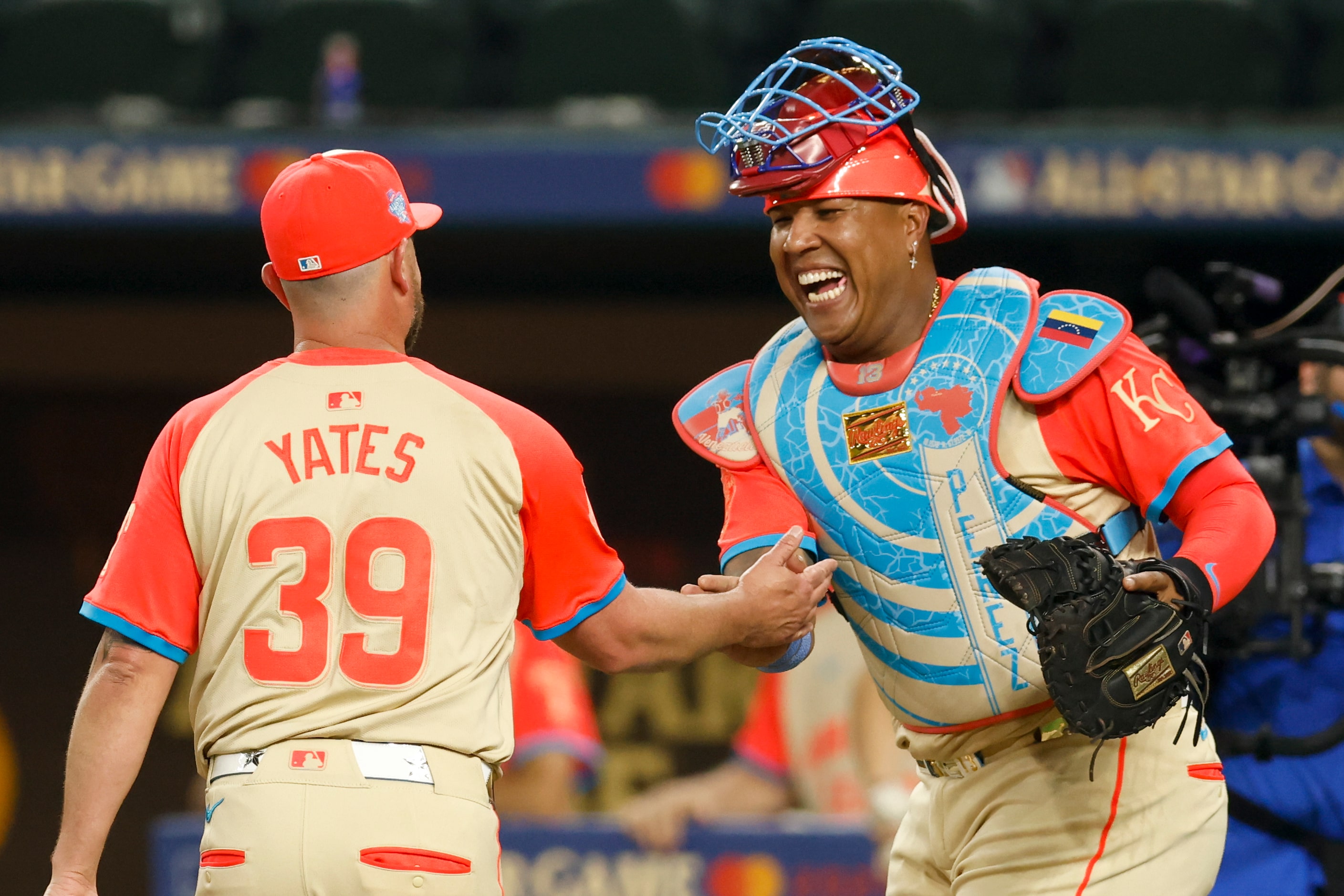 American League's Salvador Perez, of the Kansas City Royals, laughs with relief pitcher...