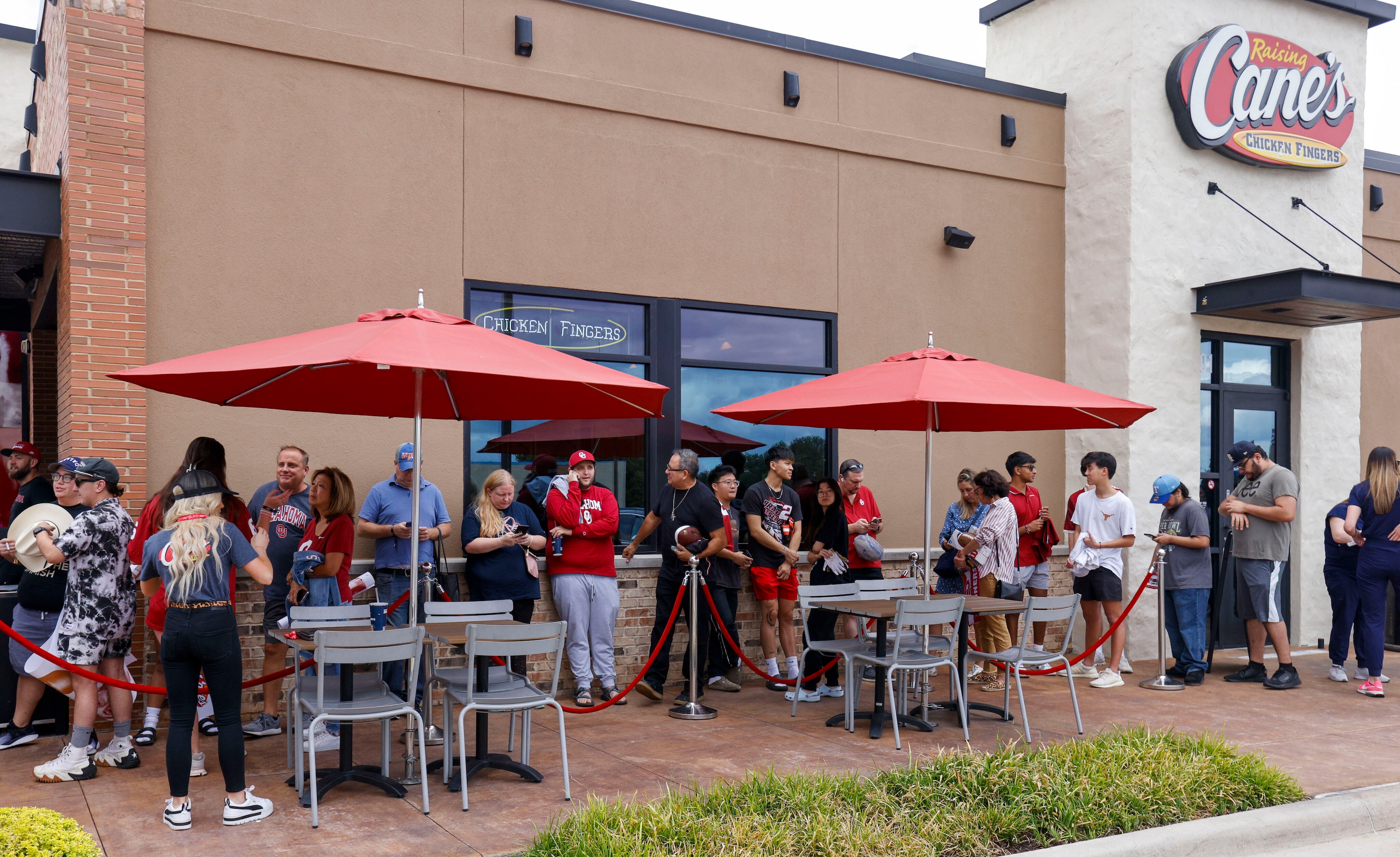 Texas and Oklahoma fans wait outside to meet former Oklahoma quarterback Baker Mayfield and...