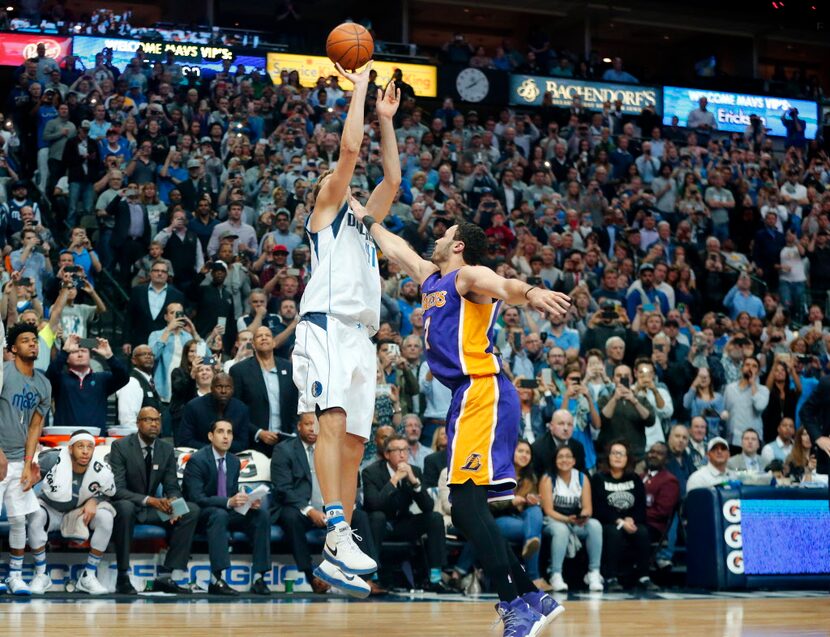 In front of his own bench, Dallas Mavericks forward Dirk Nowitzki (41) shoots and makes his...