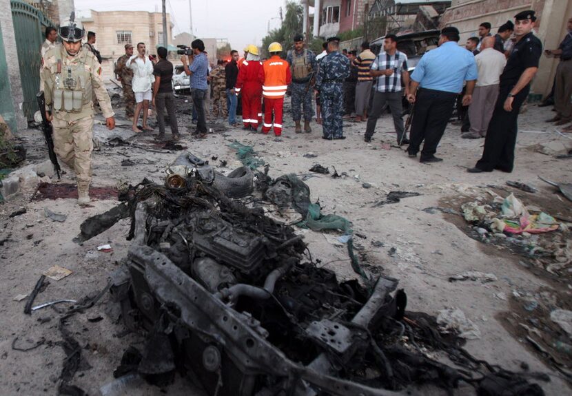 In this picture taken on Sunday, July 14, 2013, security forces inspect the scene of a car...