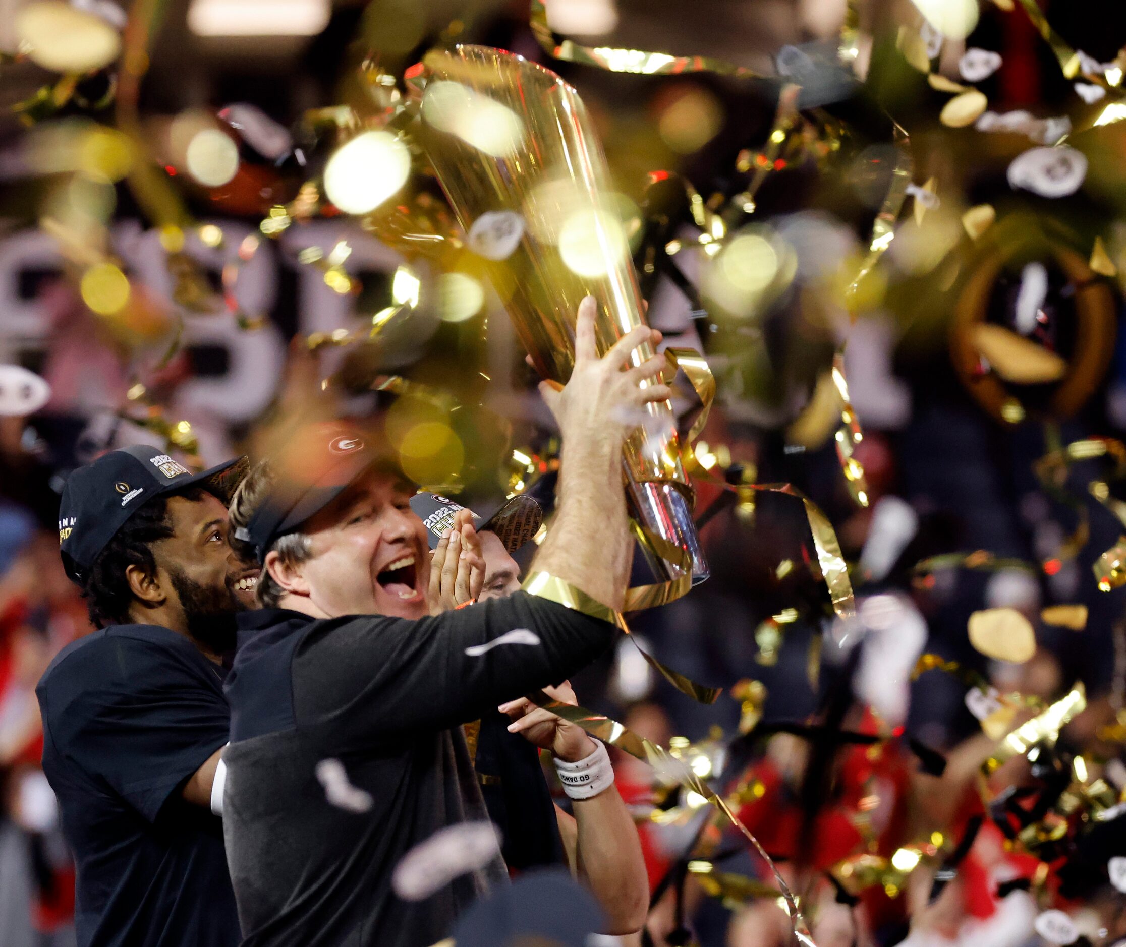 Under a hail of confetti, Georgia Bulldogs head coach Kirby Smart raises the CFP National...